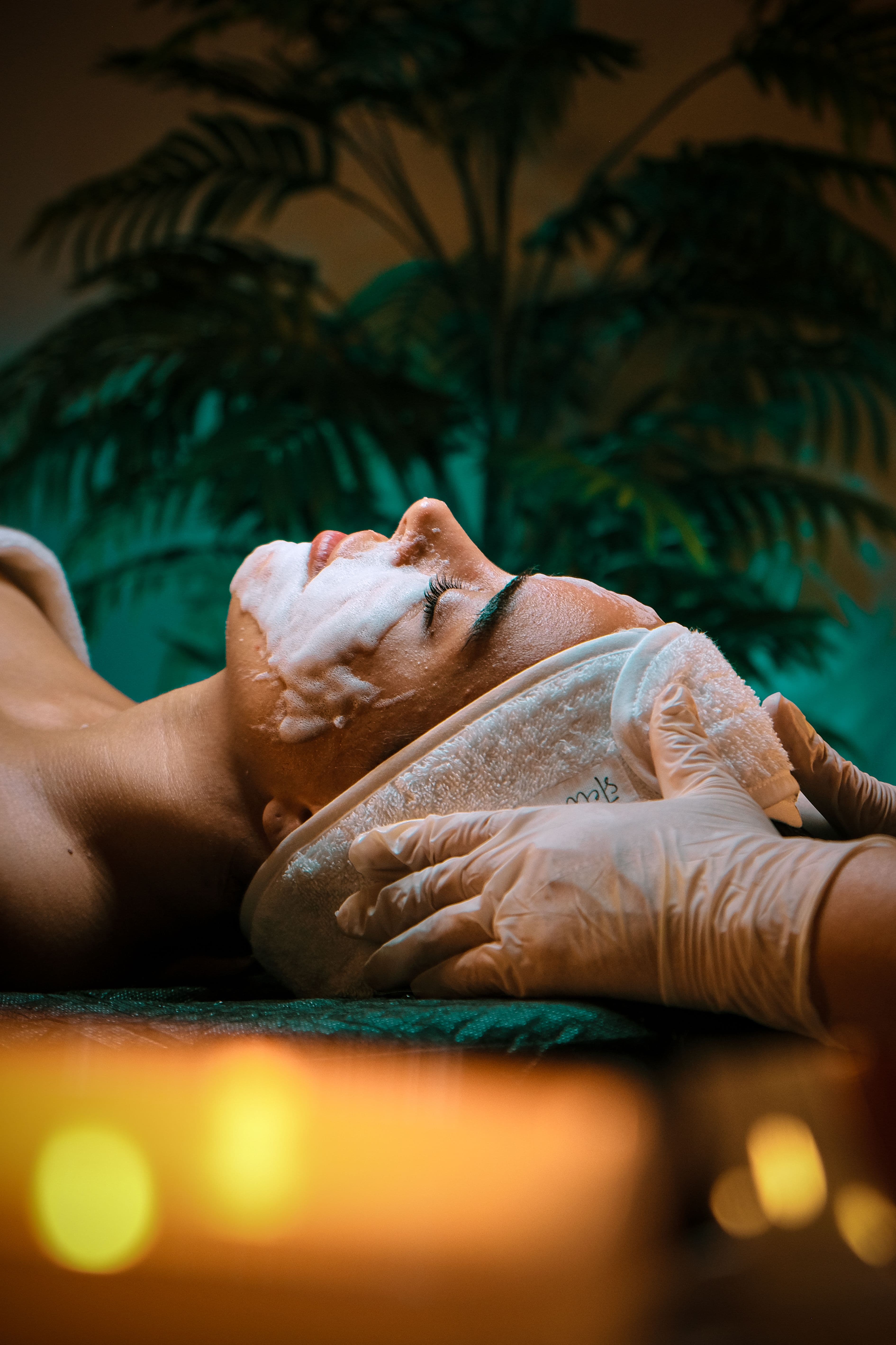 A candlelit facial treatment beneath palms